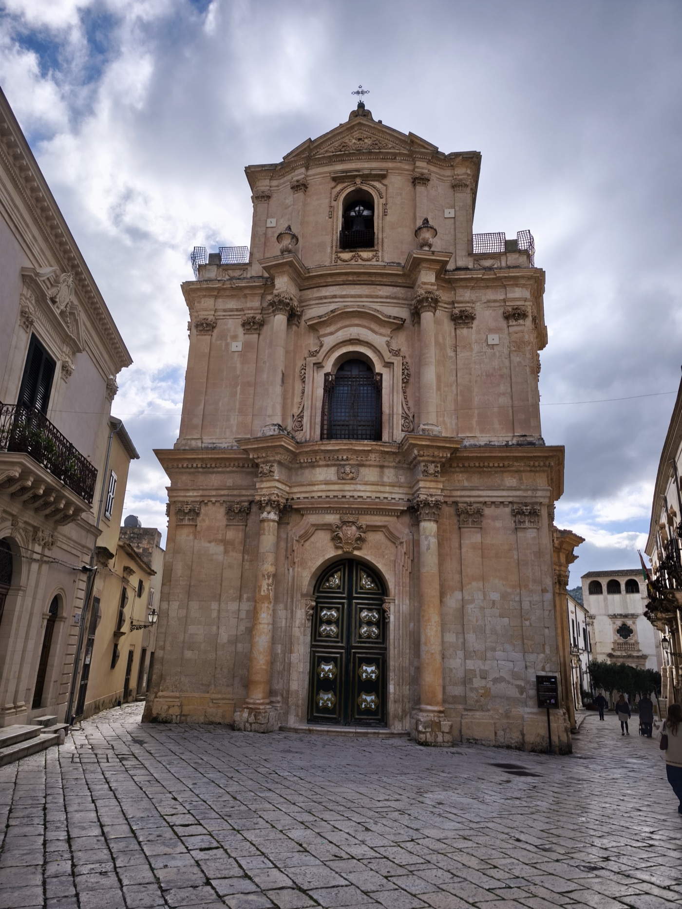 Baroque church facade in honey-coloured sandstone against a dramatic sky