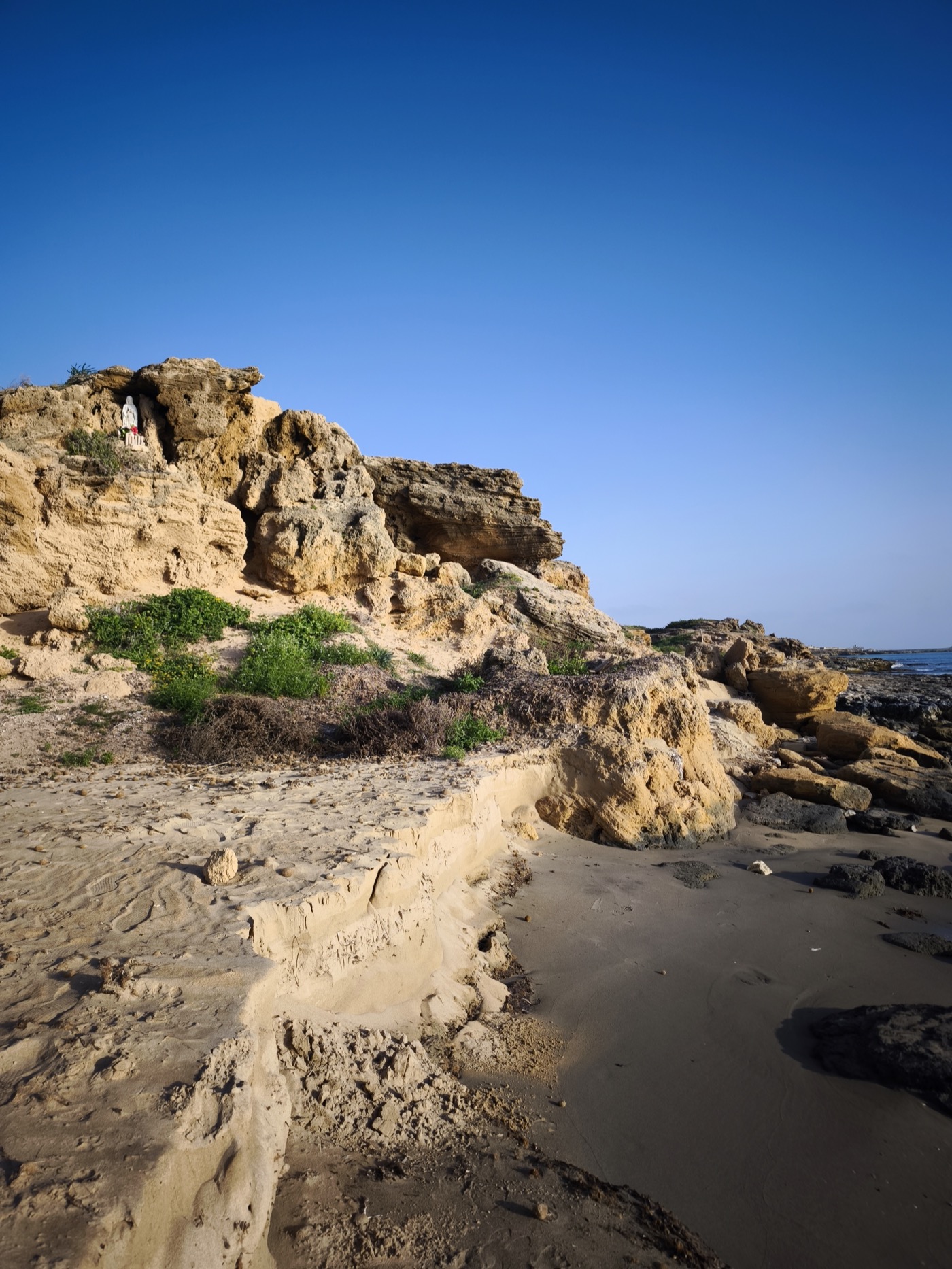 Golden sandstone rock formations along the south-eastern Sicilian coastline