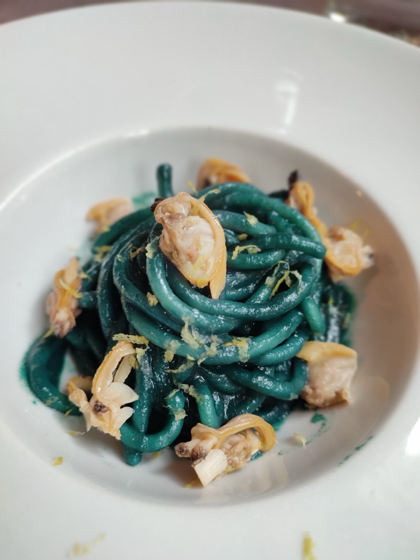 Squid ink spaghetti with clams and lemon zest served at a Sicilian restaurant