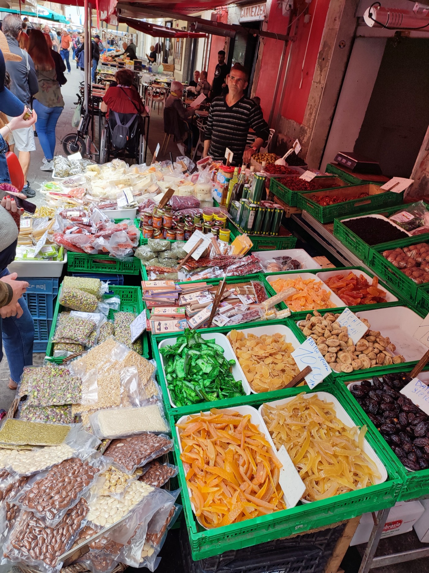 Colourful stalls at a Sicilian street market with dried fruits, nuts, and local produce